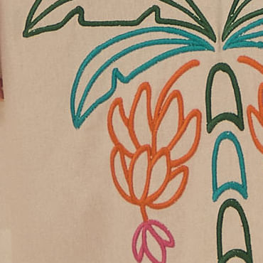 Detalle-del-bordado-en-la-barra-del-vestido-con-elementos-de-piña-y-follajes.