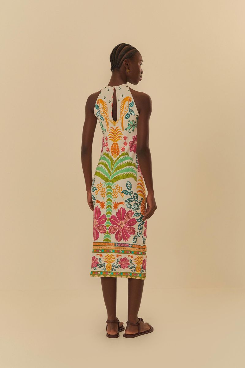 Imagen de un vestido midi con estampado tropical, mostrando la parte trasera del vestido con detalles de flores y hojas.