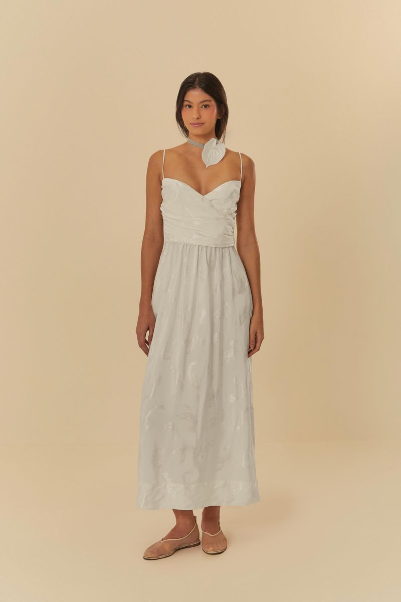 Acercamiento al escote cruzado del vestido blanco con textura jacquard.