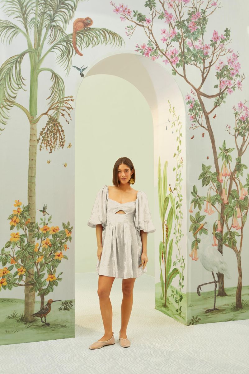 Vestido corto con estampado jacquard, escote en V y falda fluida, mostrado en un ambiente con decoración inspirada en la naturaleza.
