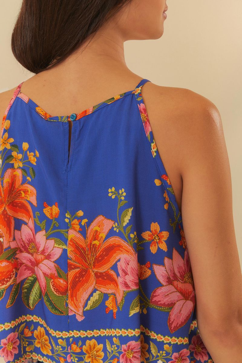 Musculosa estampada con flores tropicales y follaje en fondo azul, detalle de la espalda.