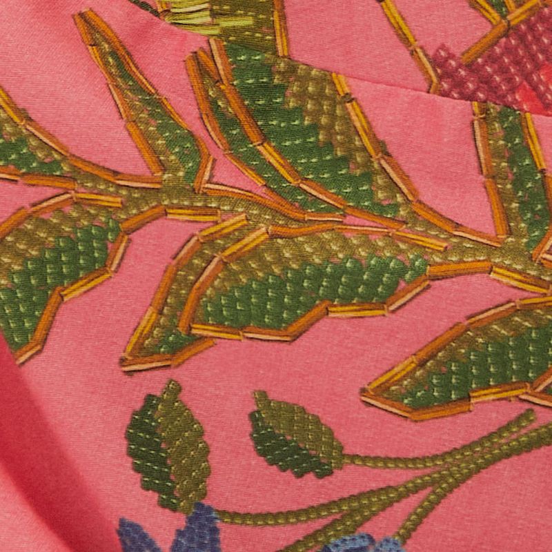 Primer-plano-de-la-tela-del-vestido-destacando-el-patron-detallado-de-frutas-y-hojas-tropicales.