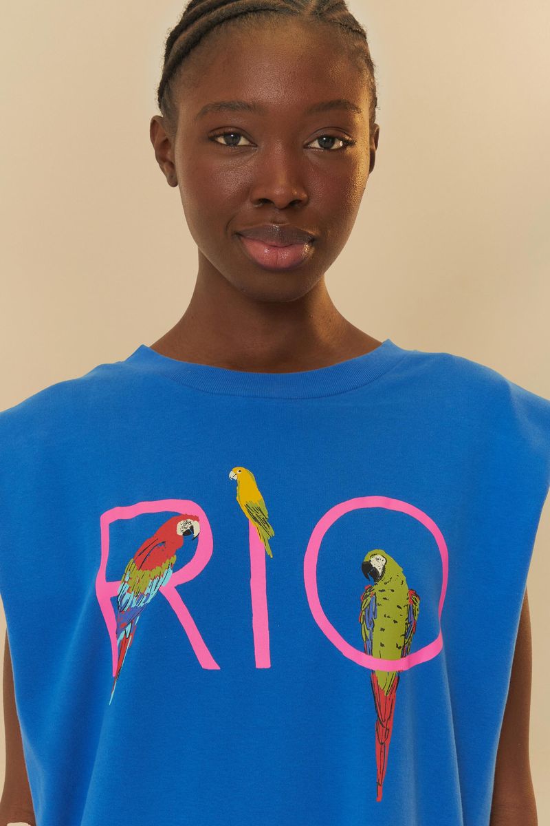 Detalle del escote del vestido azul con estampado de guacamayas y texto 'RIO'.