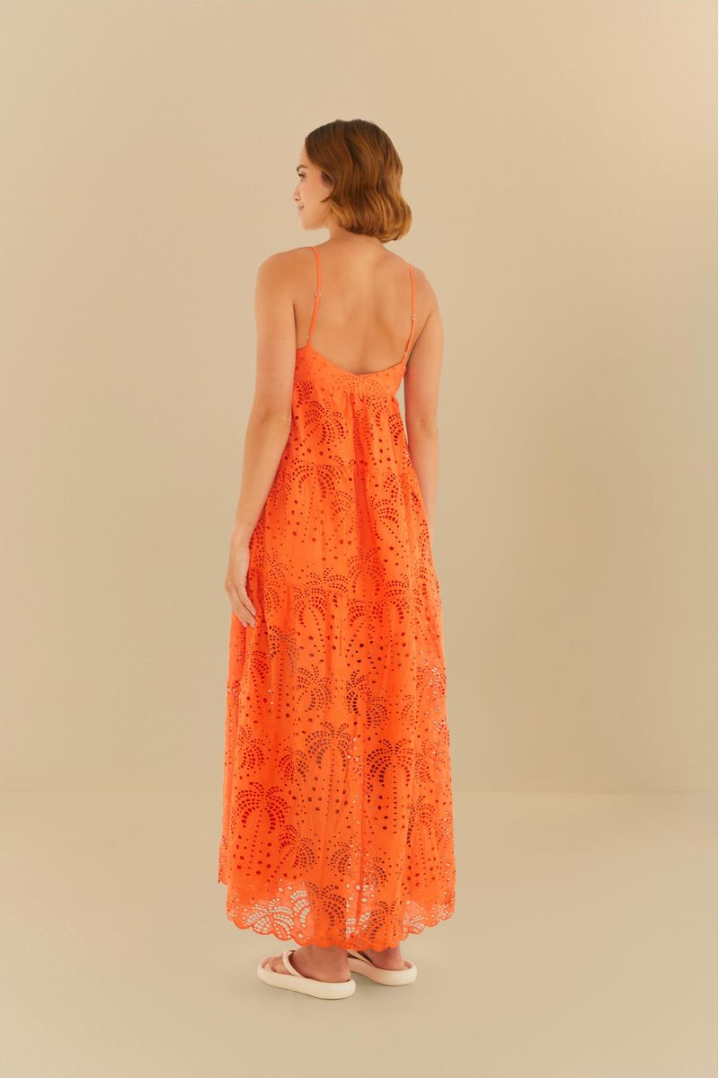 Close-up del escote profundo en V del vestido naranja con bordado floral en laise, mostrando el detalle de lazado.