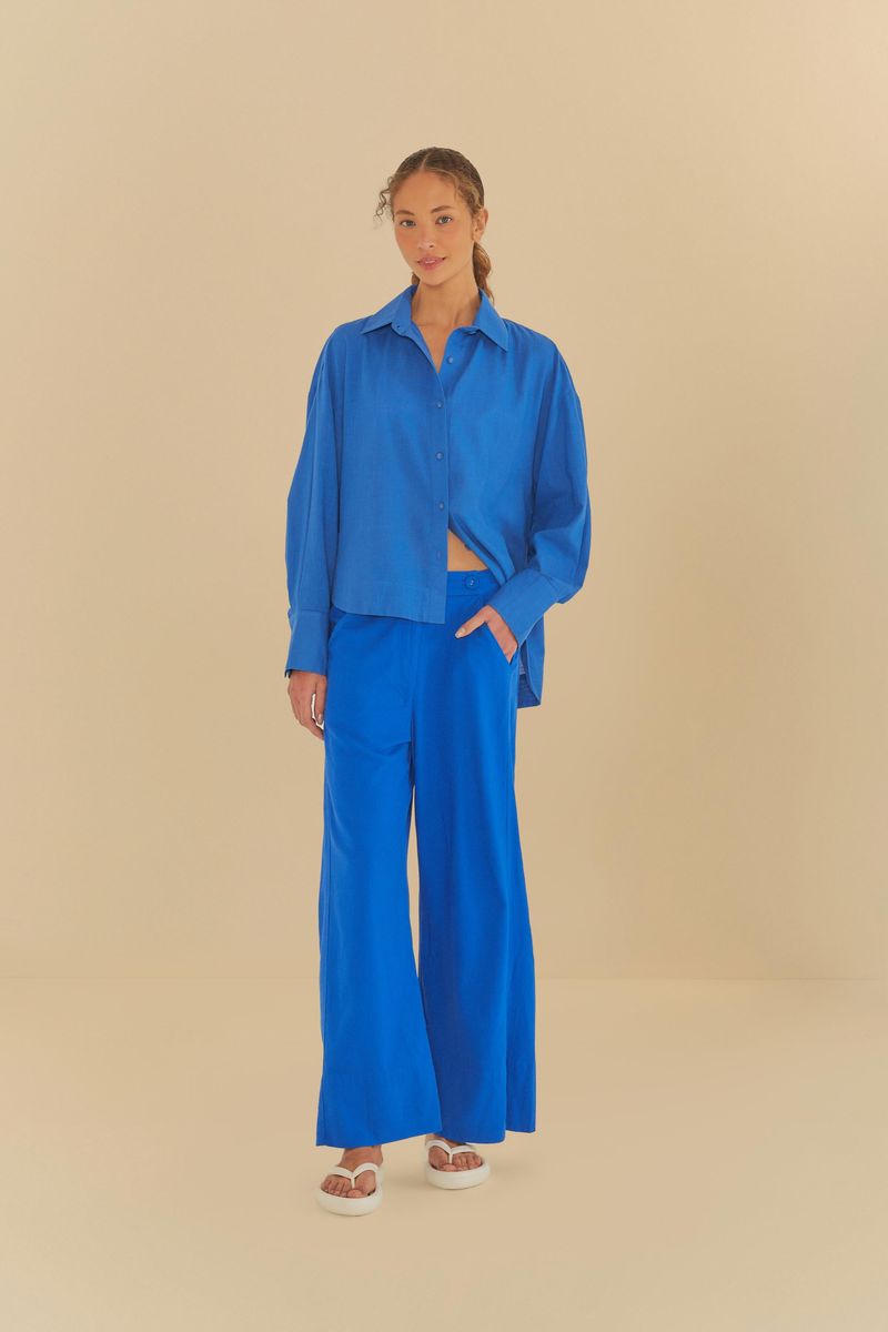 Modelo usando pantalón azul con camisa azul, mostrando el conjunto completo.