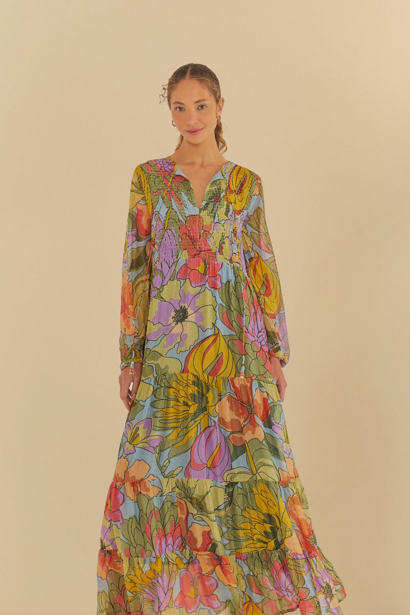 Vestido largo con estampado floral vibrante, escote en V y mangas largas, mostrado en un fondo neutro.
