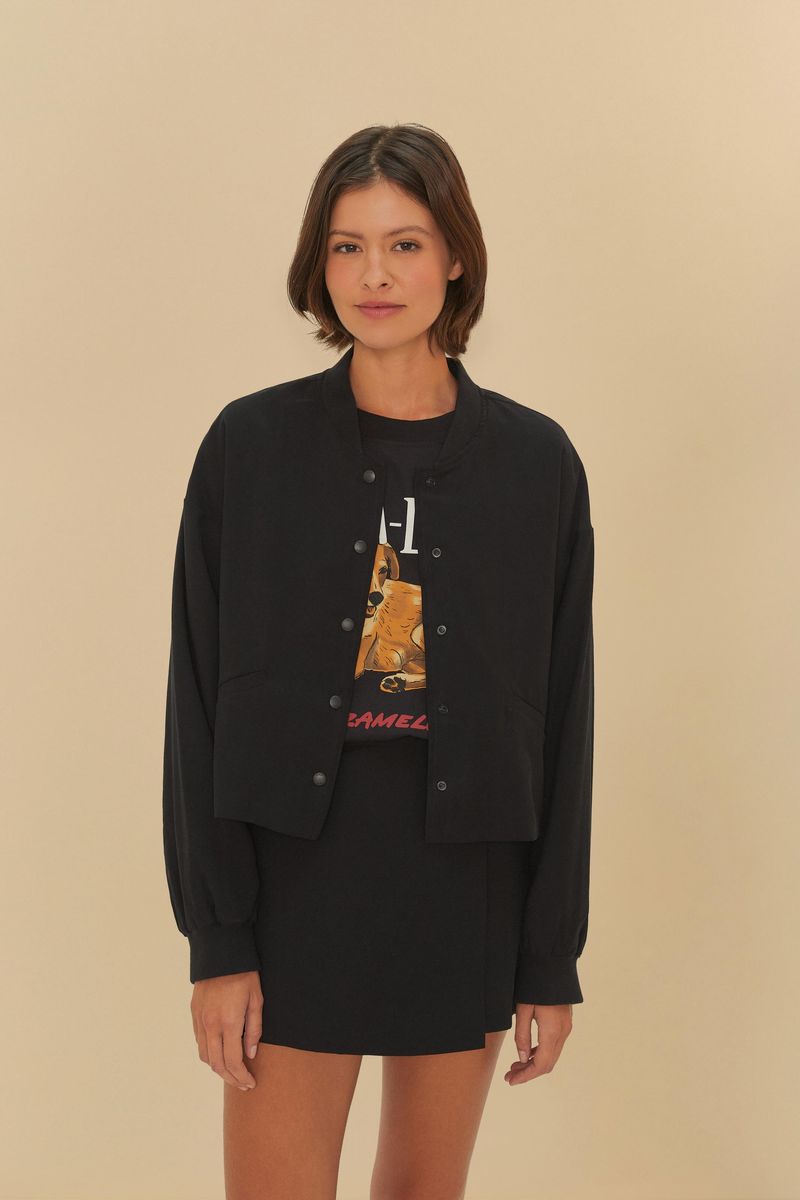Chaqueta-bomber-negra-con-diseño-minimalista-vista-frontal-con-modelo-usandola.