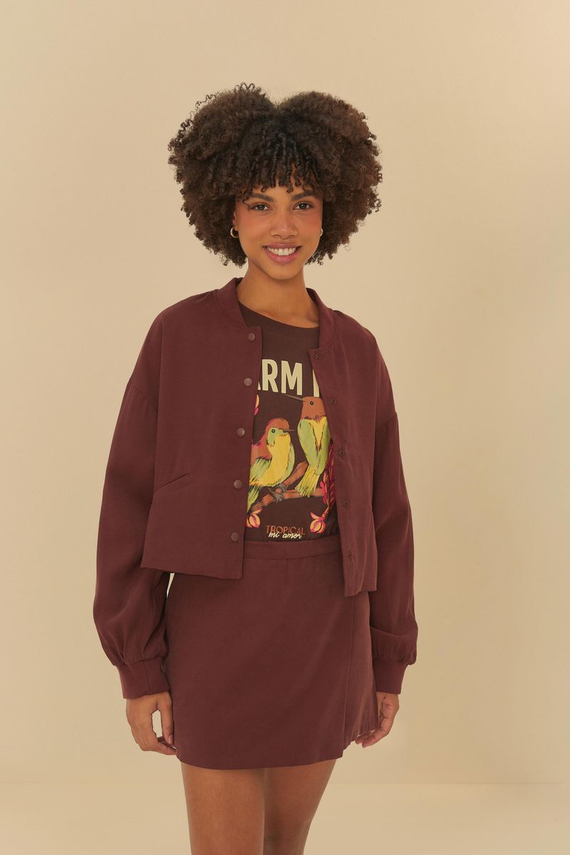 Chaqueta-bomber-en-sastreria-marron-abierta-mostrando-una-camiseta-estampada-debajo-vista-frontal.