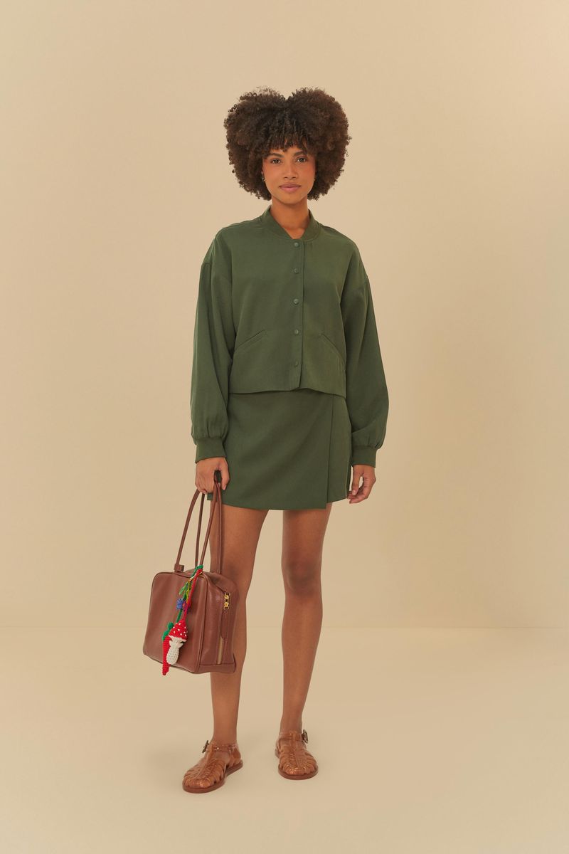 Modelo vistiendo short saia de alfaiataria verde oscuro con blusa combinando.