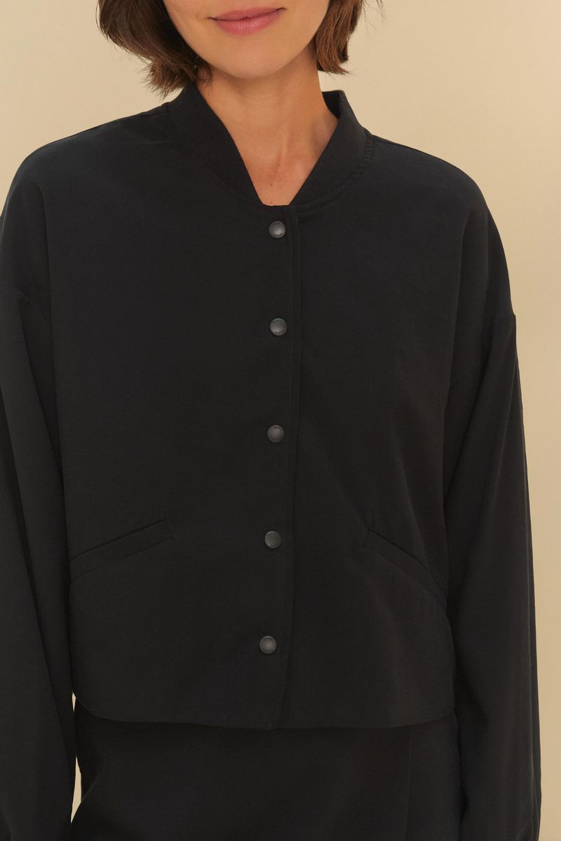 Detalle-del-cuello-mandarin-y-cierre-con-botones-de-la-chaqueta-bomber-negra.