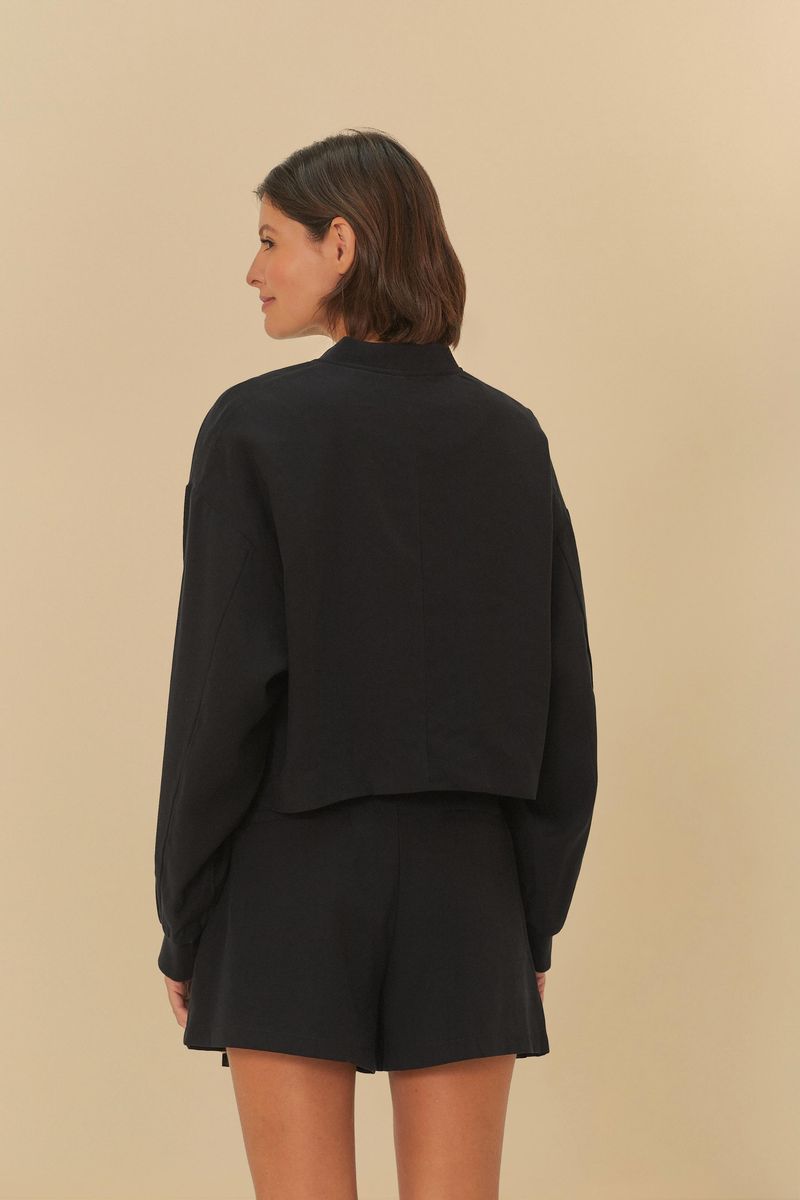 Vista-trasera-de-la-chaqueta-bomber-negra-mostrando-el-corte-y-caida.