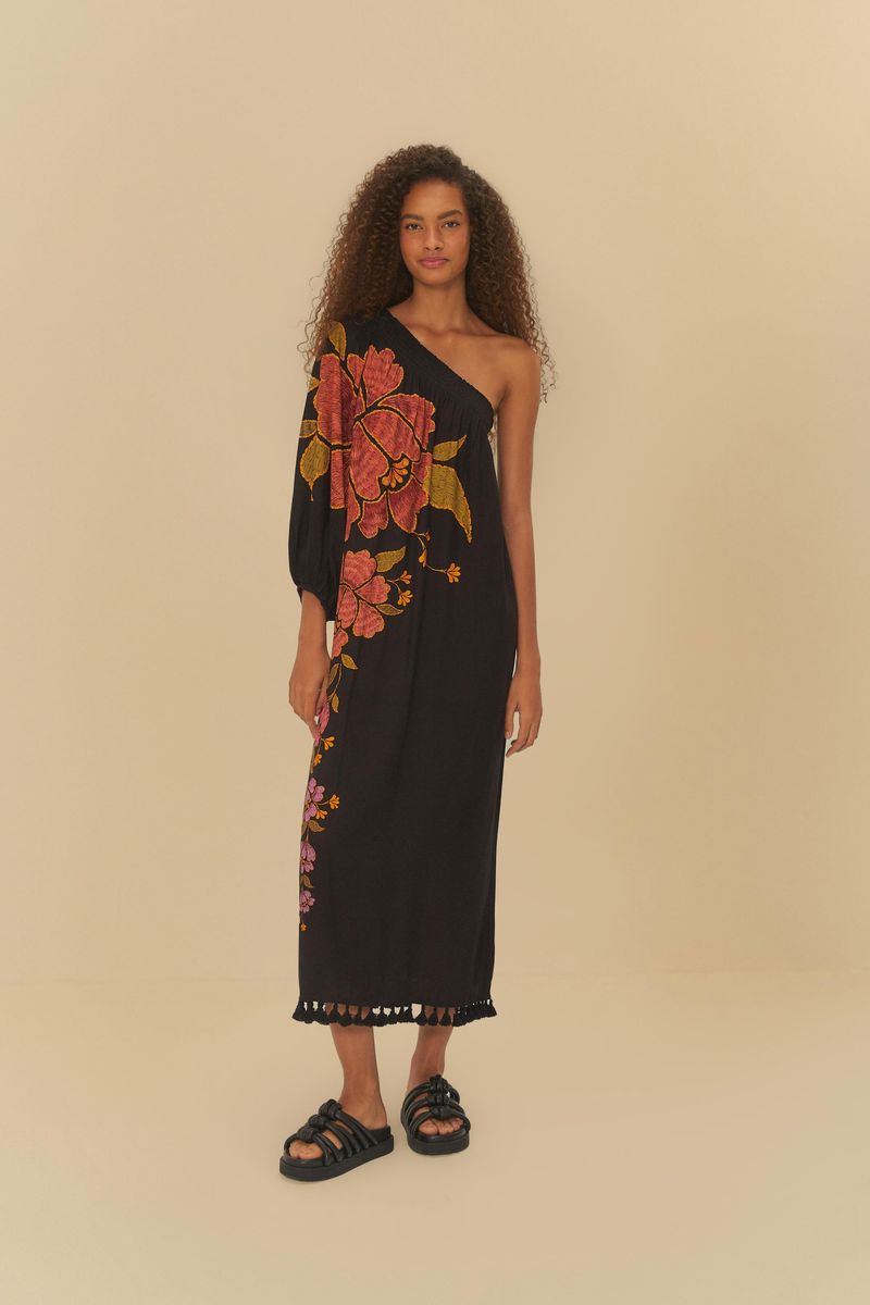 Vestido negro con estampado floral en tonos rojos y amarillos, diseño de un solo hombro, largo, con detalles en el dobladillo.