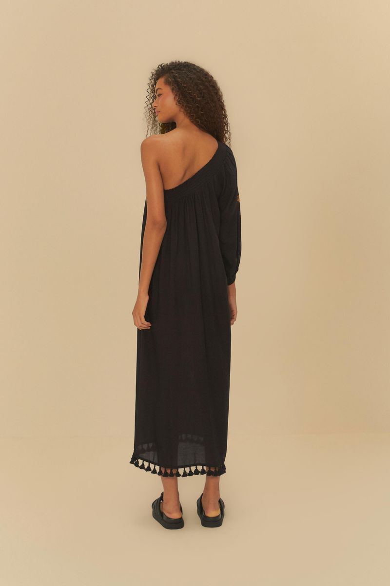 Vista trasera del vestido negro con estampado floral, evidenciando la caída y el diseño del dobladillo.