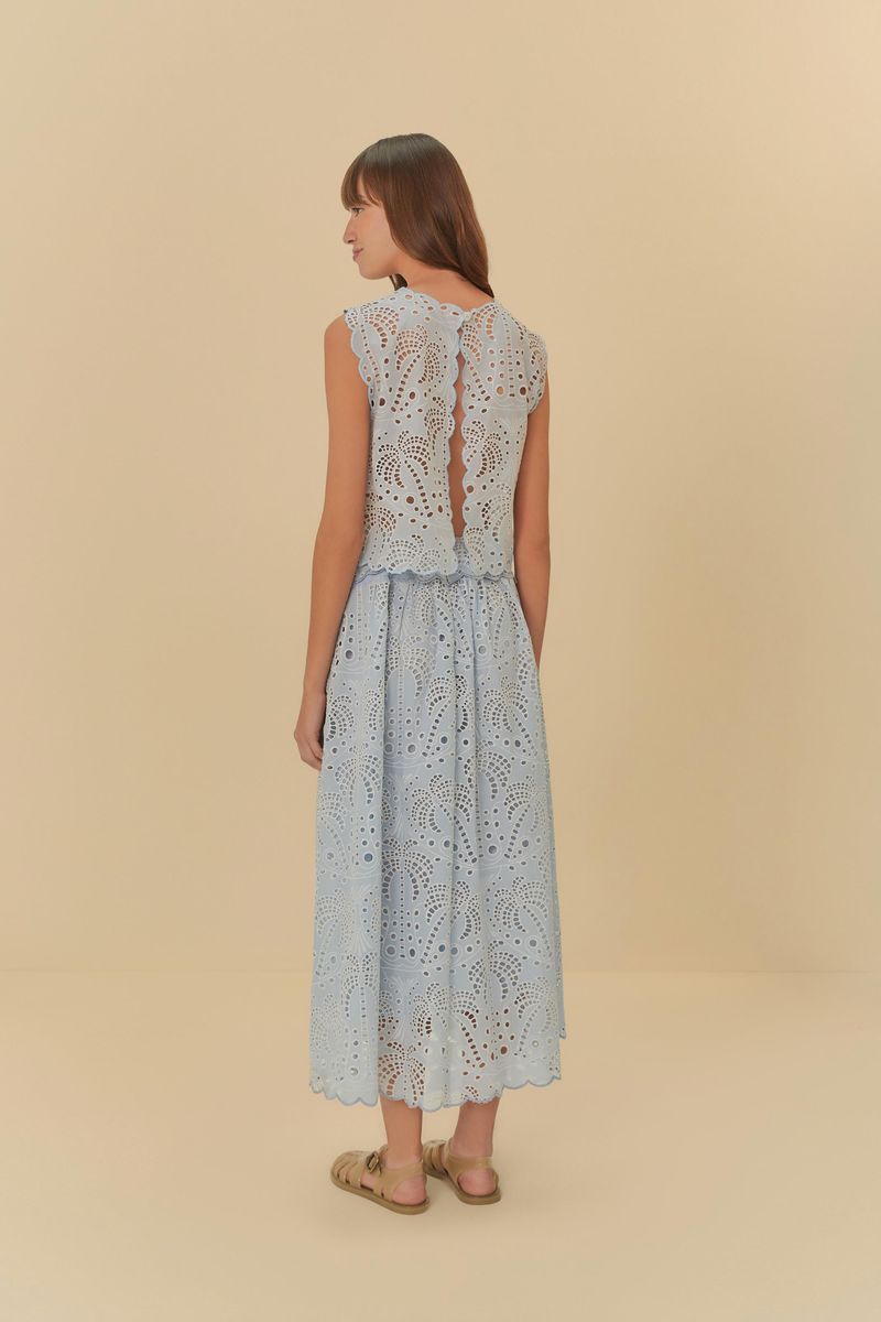 Una imagen de una falda cropped de laise azul claro en primer plano, destacando los detalles calados y la textura del tejido.