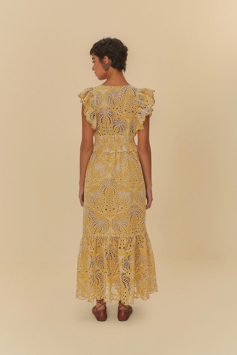 Imagen mostrando un acercamiento del escote y detalles del vestido amarillo con laise y estampado de palmeras.