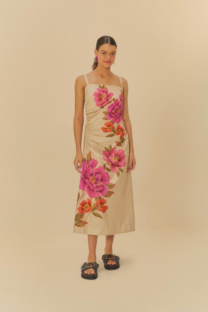 Vestido midi con estampado floral sobre fondo beige, tirantes finos y detalle drapeado en el frente.