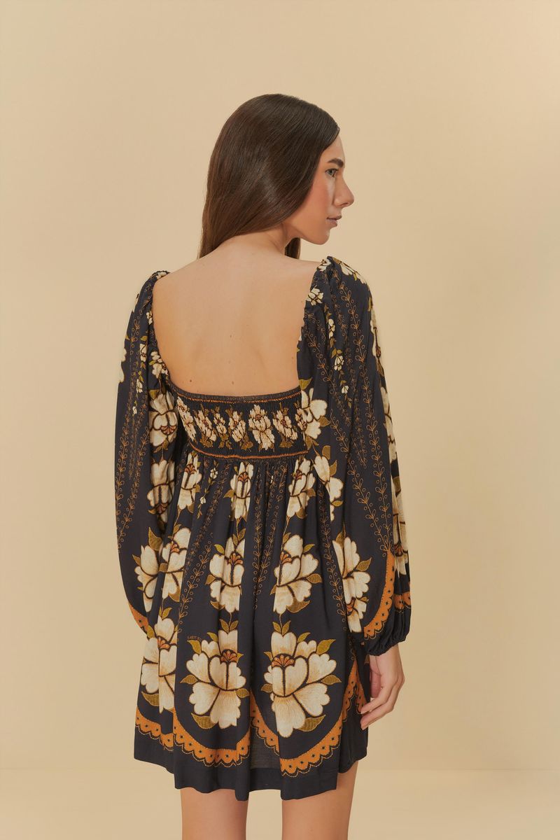 Vista trasera del vestido corto con estampado floral, destacando el escote en la espalda y las mangas largas abullonadas.