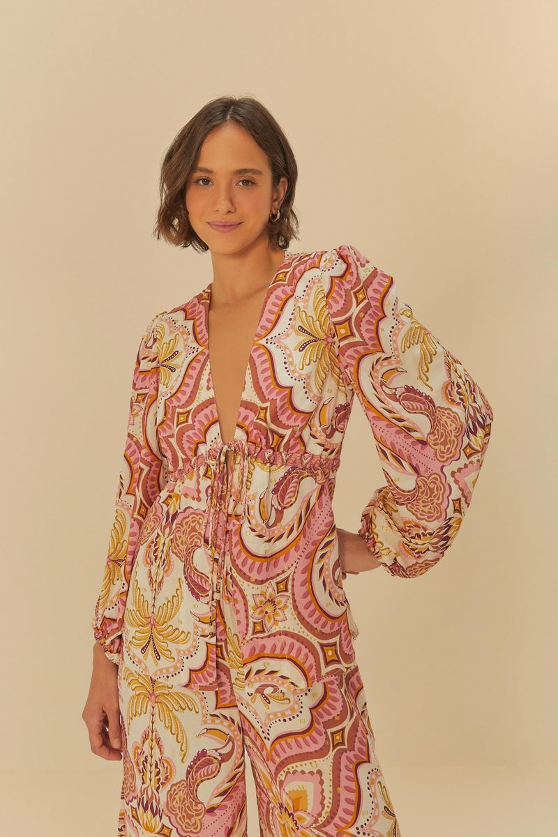 Imagen de una blusa estampada con motivo tropical, vista frontal con escote en V y mangas abullonadas.