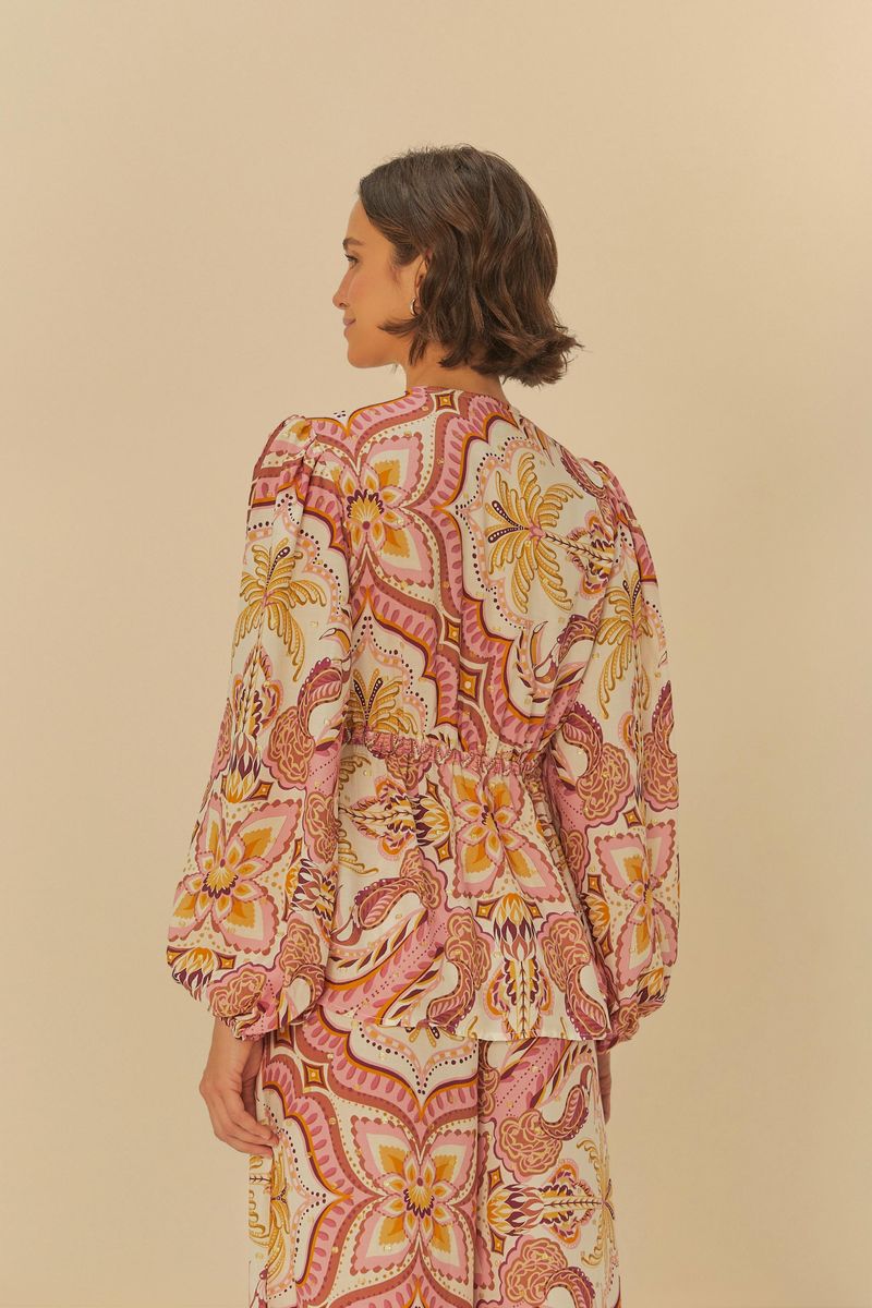 Imagen de una blusa estampada con motivo tropical, vista trasera mostrando el diseño de la espalda.