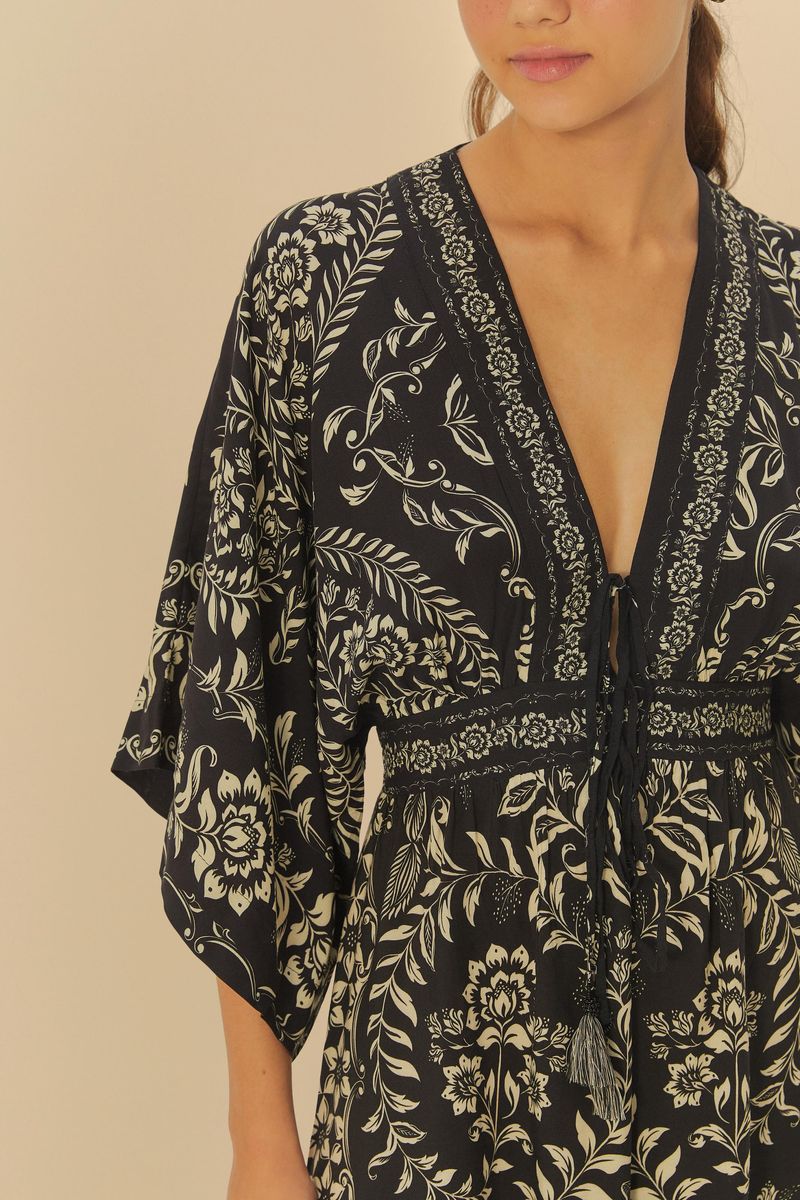 Primer-plano-del-escote-en-V-del-vestido-largo-con-estampado-floral-en-fondo-oscuro.