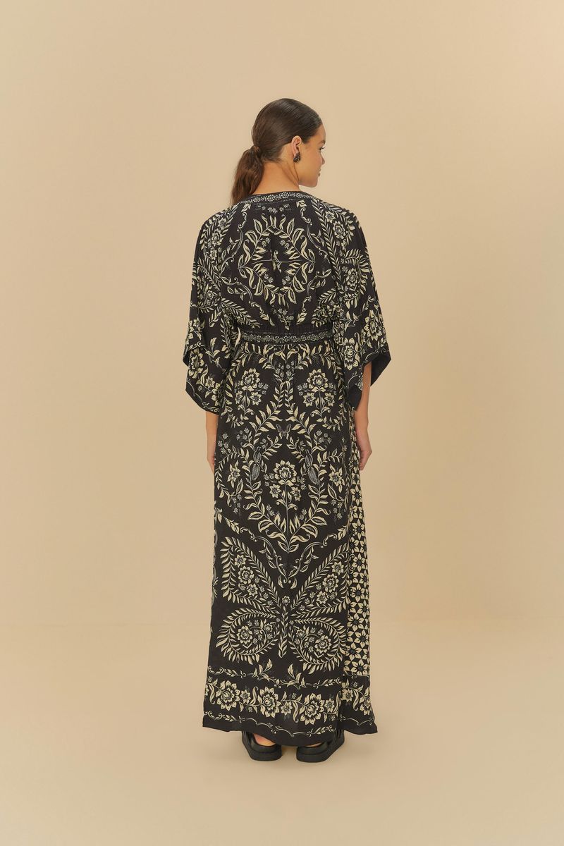 Vista-trasera-del-vestido-largo-con-estampado-floral-en-fondo-oscuro-destacando-el-diseño-de-la-espalda.
