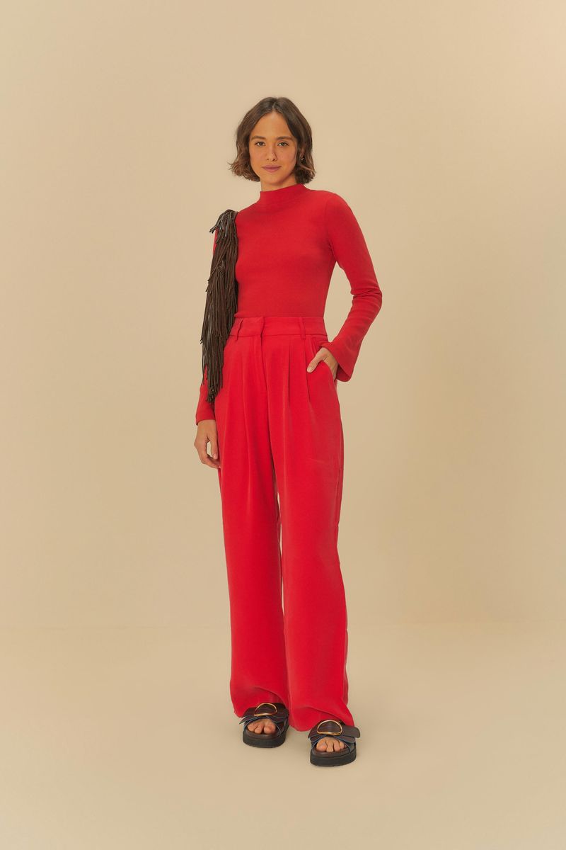 Modelo llevando pantalón recto de sastrería rojo con blusa de manga larga roja, vista frontal.