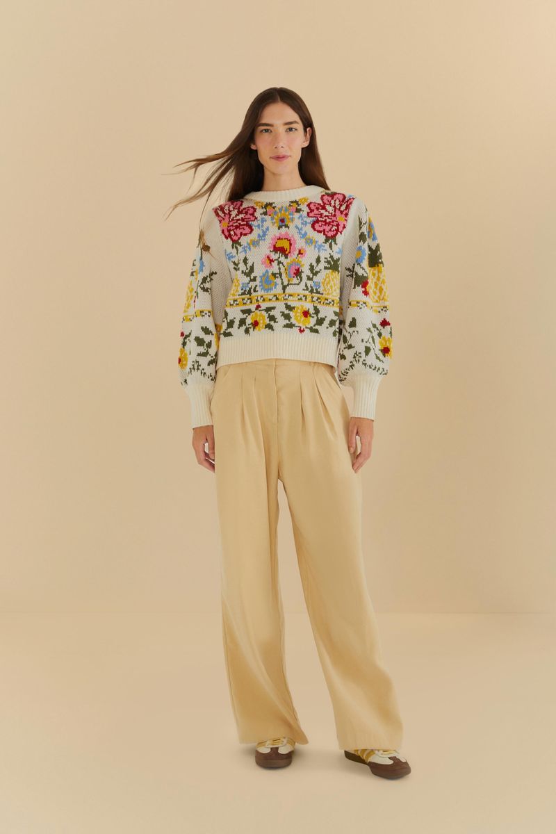 Imagen de un pantalón recto de sastrería beige combinado con una blusa floral.