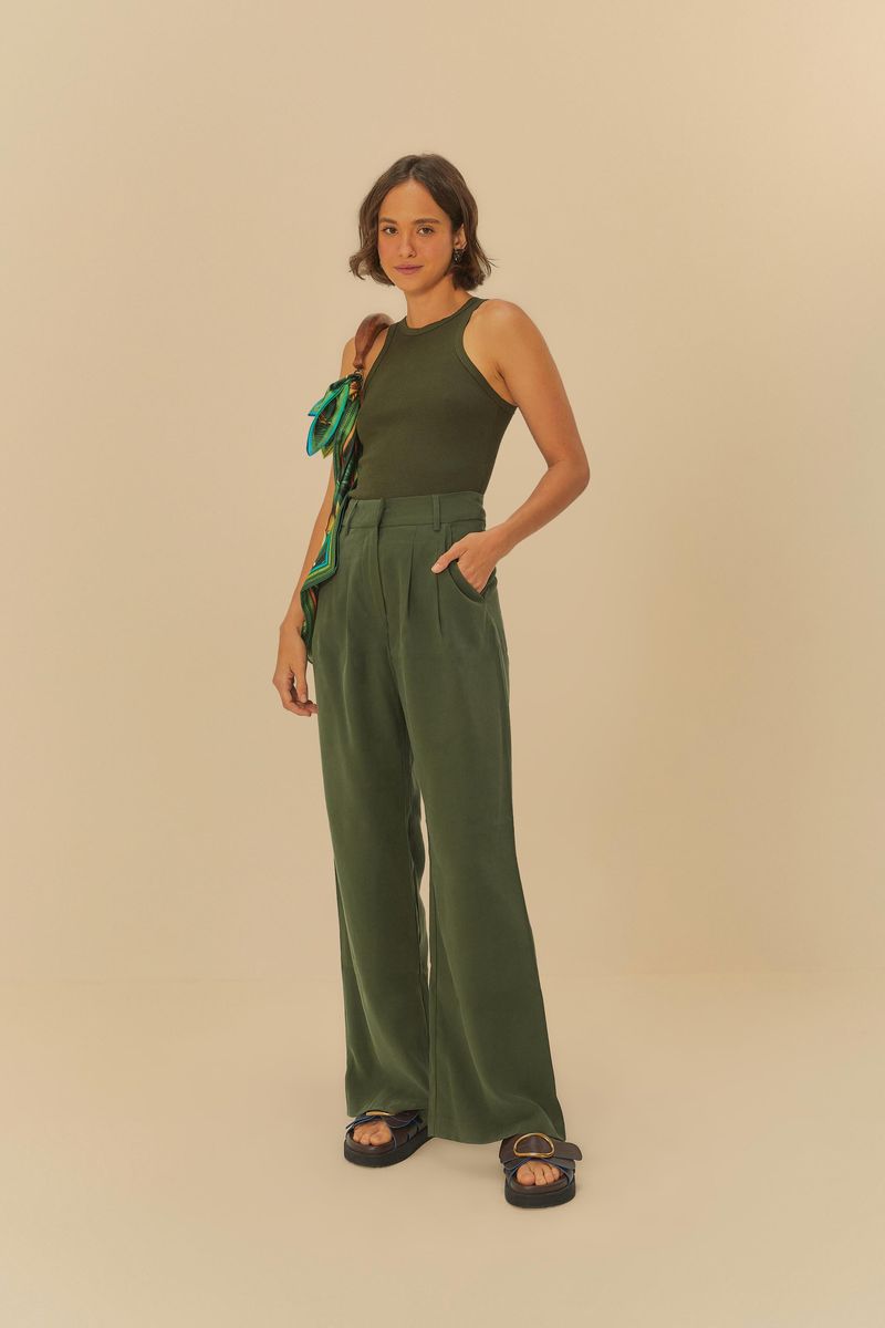 Modelo usando pantalón recto de sastrería verde oscuro con top sin mangas