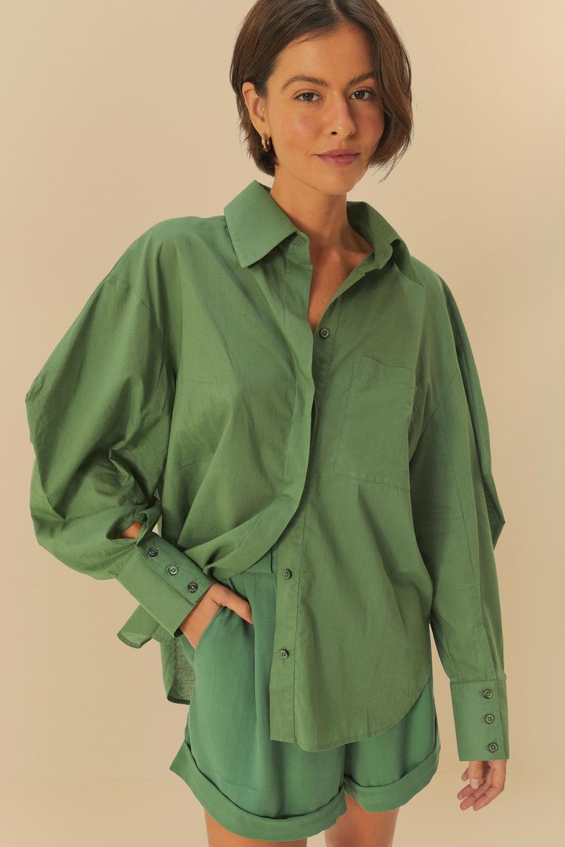 Acercamiento de la camisa verde con detalles de sastrería.