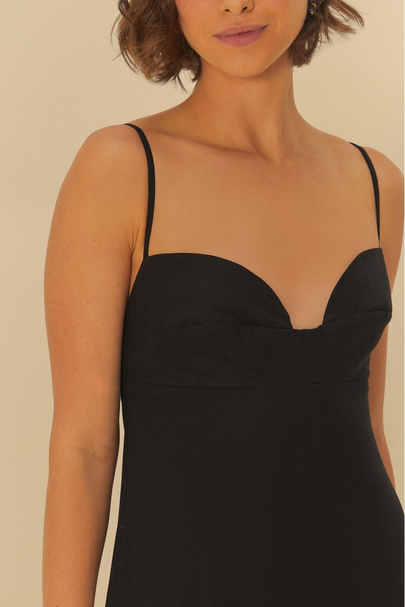 Detalle del escote del vestido negro con tirantes delgados.