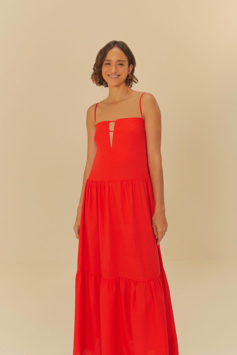 Imagen de un vestido largo rojo con tirantes y abertura frontal, visto de lado.