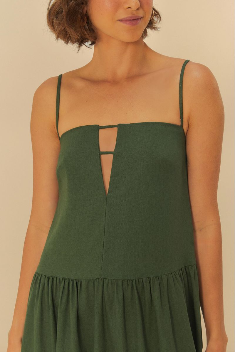 Imagen de un vestido largo verde con tiras delgadas y abertura frontal, visto desde atrás.