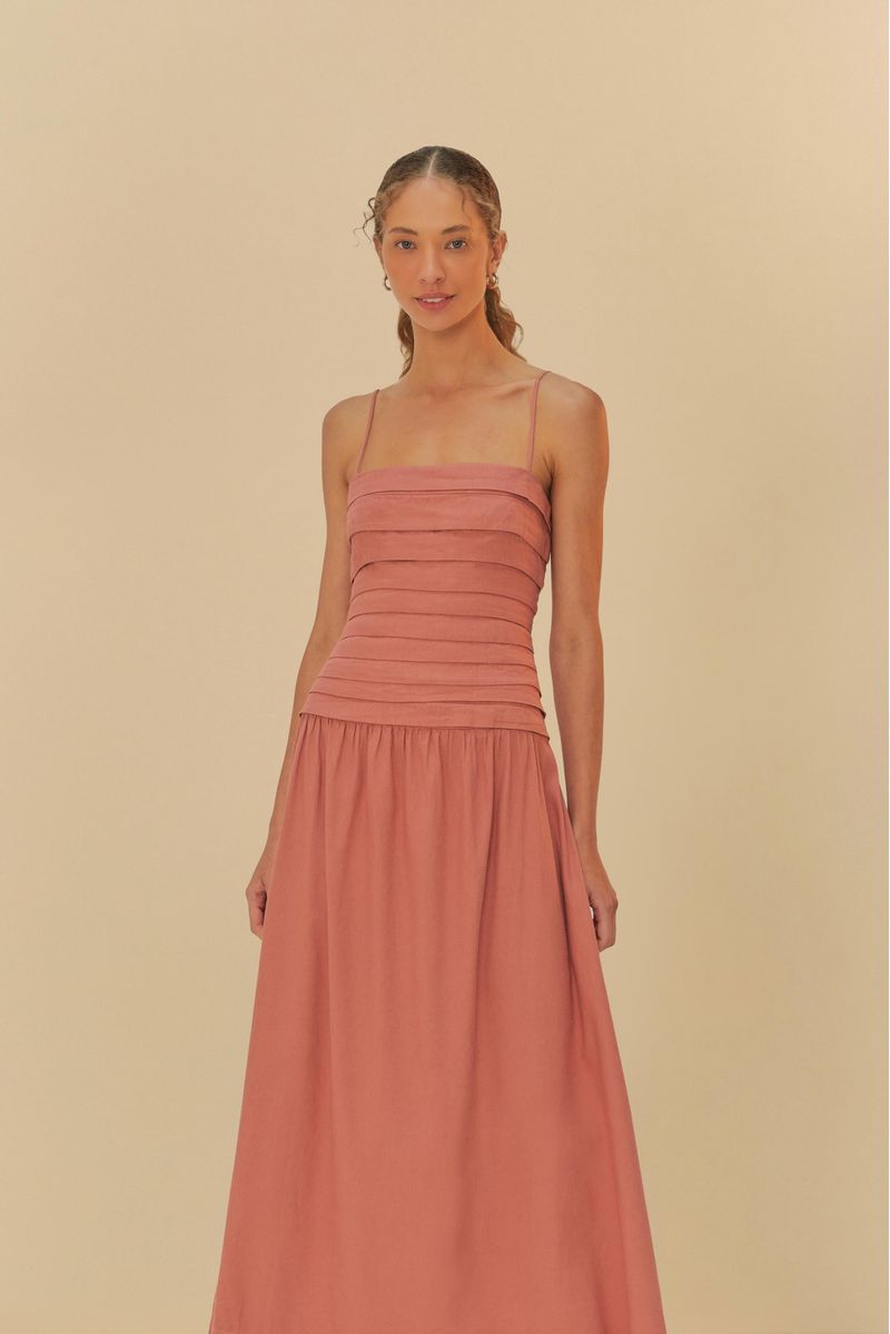 Vestido cropped con pliegues en tono terracota, visto de lado.