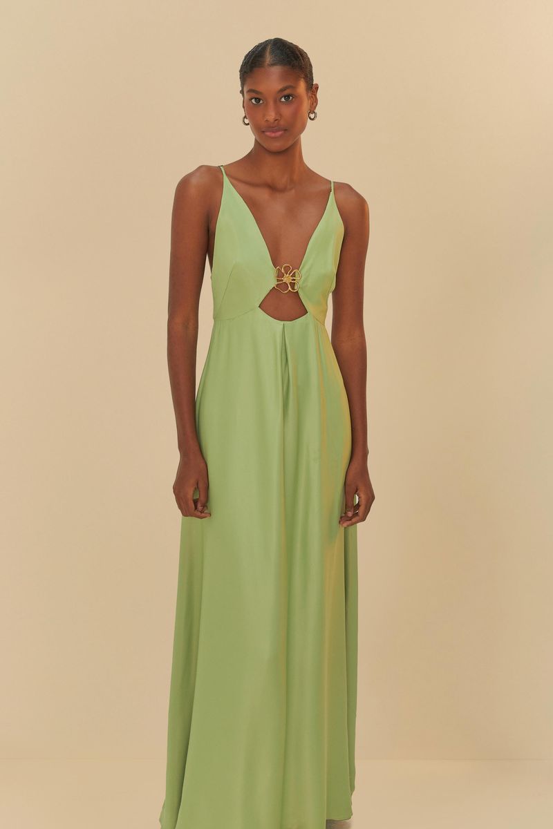 Imagen de un vestido largo verde con detalle en el busto, visto de lado.