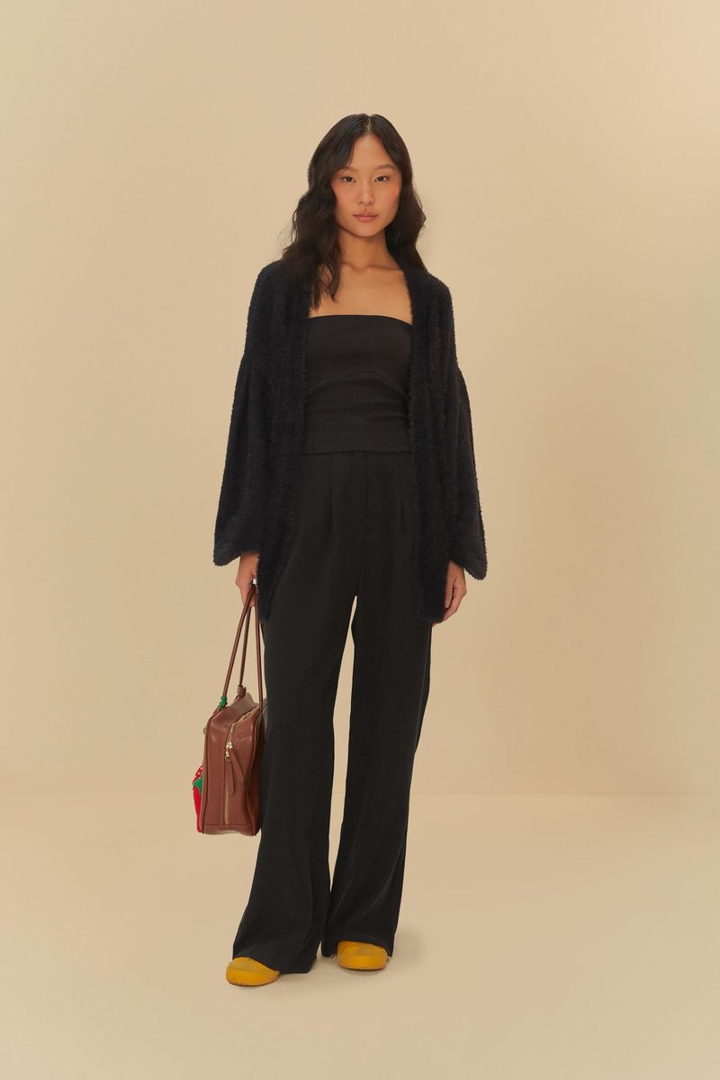 Modelo-vistiendo-cardigan-tricot-pelinho-negro-con-pantalon-negro-y-bolso-marron.