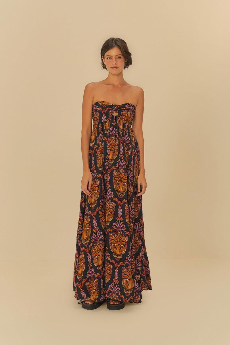 Imagen mostrando un vestido largo estampado con patrón boho, con detalles en naranja y morado sobre fondo negro, visto de frente en posición recta.