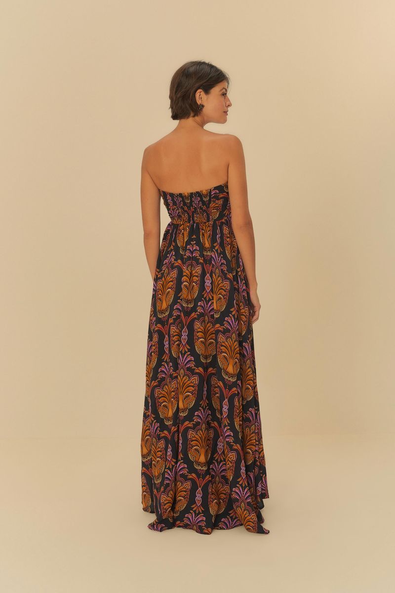 Imagen mostrando un vestido largo estampado con patrón boho, con detalles en naranja y morado sobre fondo negro, con enfoque en el detalle del escote y amarre trasero.
