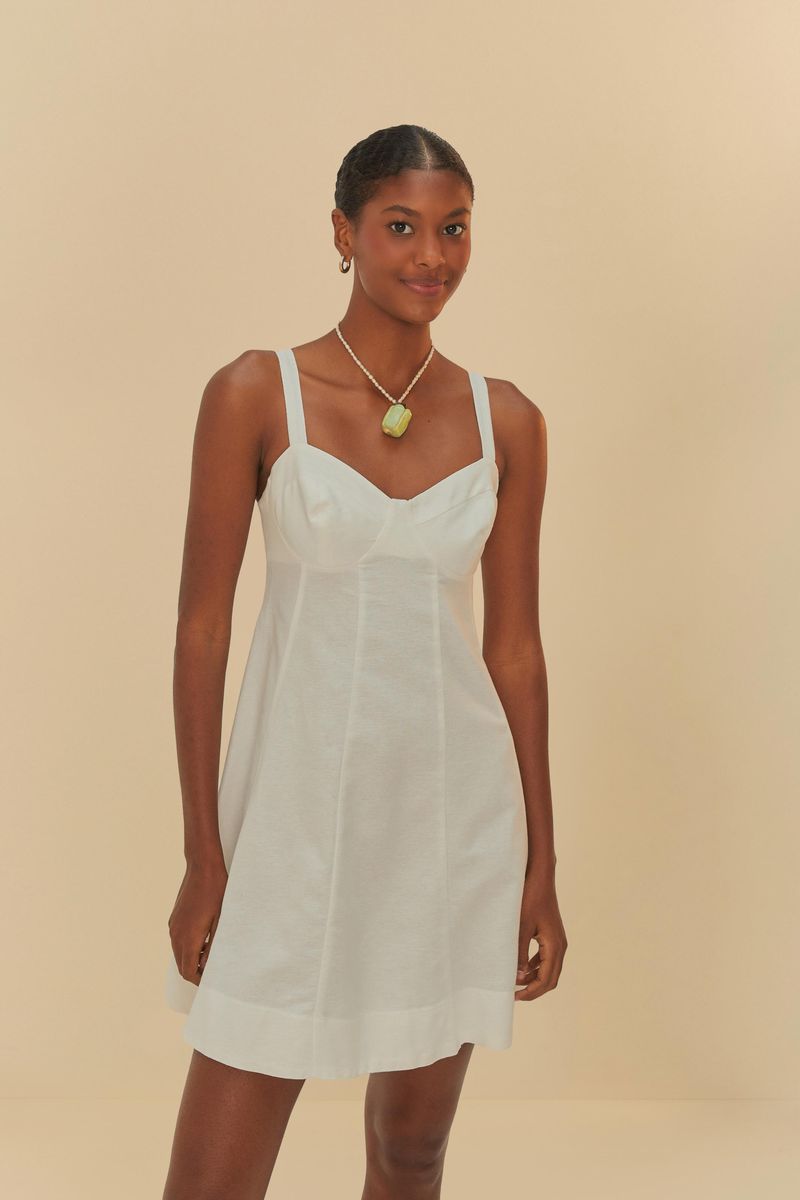 Modelo-de-piel-oscura-vistiendo-vestido-corto-blanco-con-collar-verde.