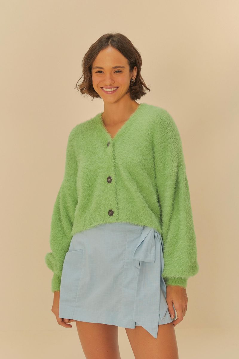 Modelo-vistiendo-short-saia-azul-claro-con-amarrado-combinando-con-un-cardigan-verde.