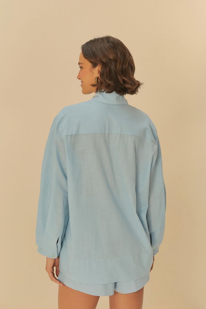 Vista lateral de la camisa azul clara mostrando la caída.