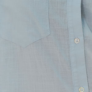 Vista-trasera-de-la-camisa-azul-clara-con-pliegues-y-dobladillo-redondeado.