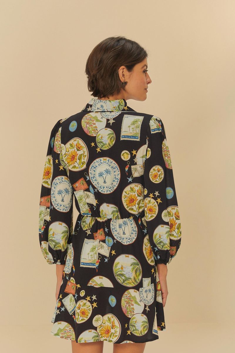 Vista trasera del vestido corto con estampado de souvenir, destacando el ajuste en la cintura y la caída suelta.