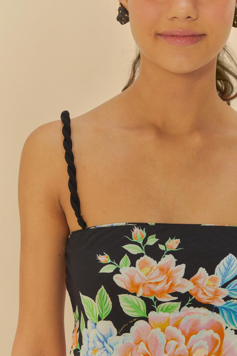 Close-up del escote de la blusa floral con tirantes trenzados.