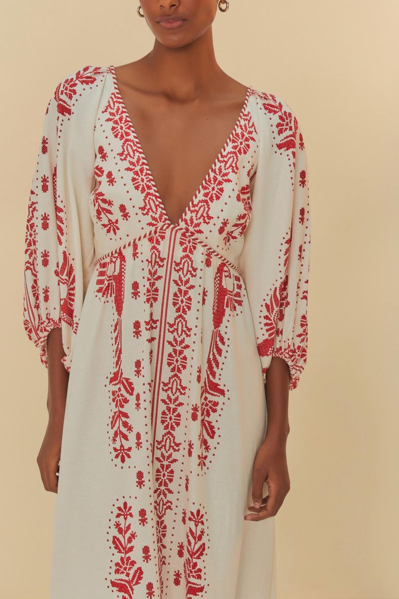 Detalle del escote en V del vestido largo con bordado tropical en rojo.