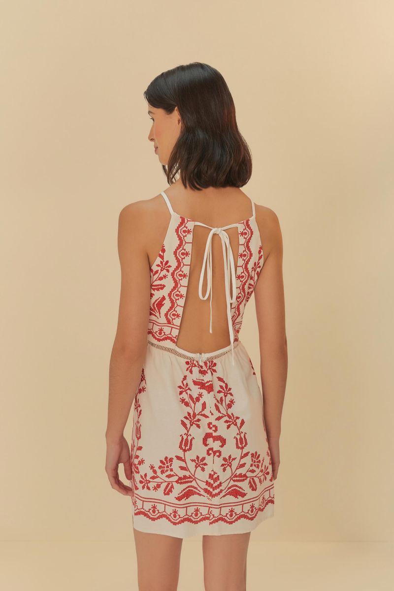 Primer plano del detalle de las espaldas abiertas con lazada del vestido corto.