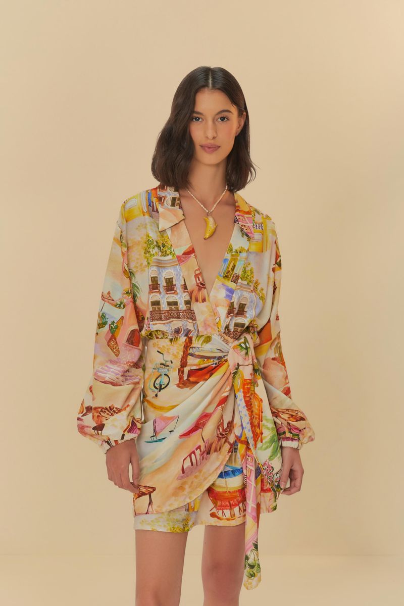 Modelo usando vestido corto cruzado con estampado tropical, vista frontal.