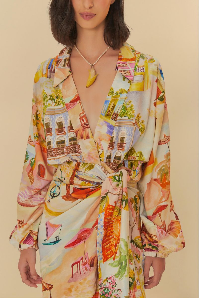 Detalle del escote cruzado y estampado tropical del vestido.