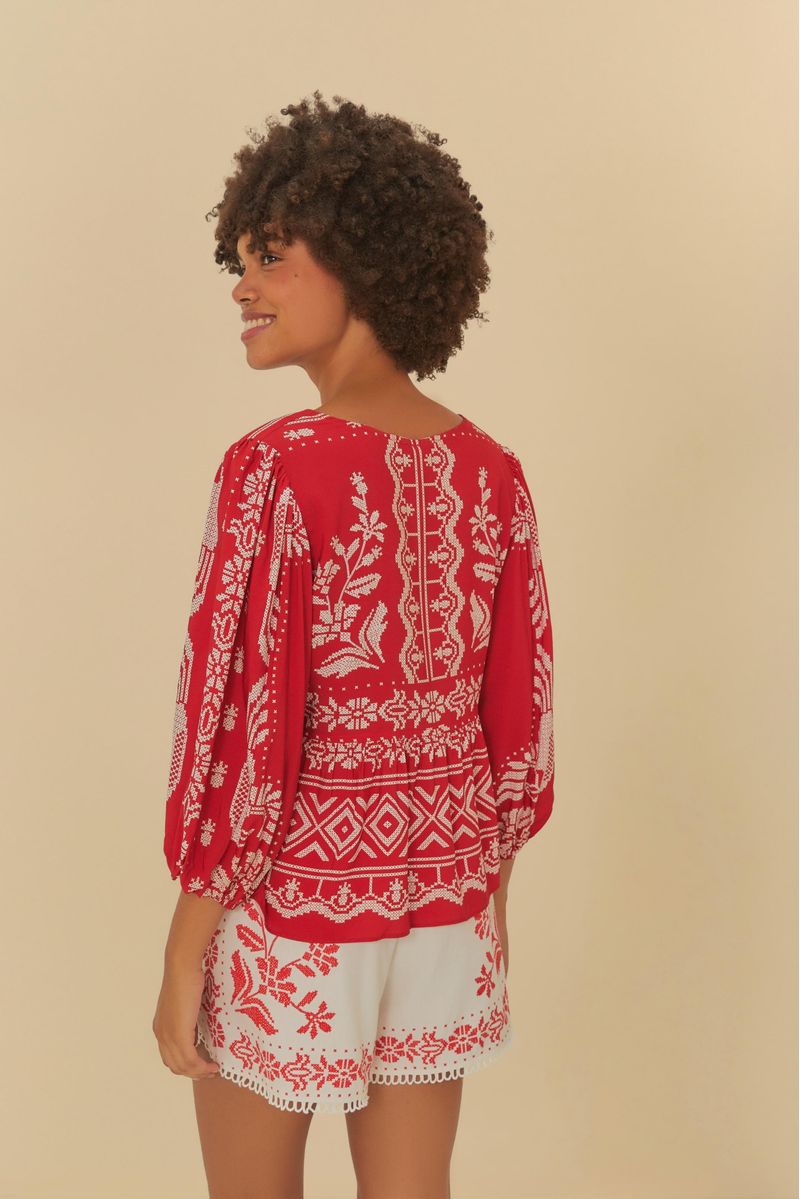 Vista trasera de la bata roja con bordado tropical, mostrando el diseño detallado.