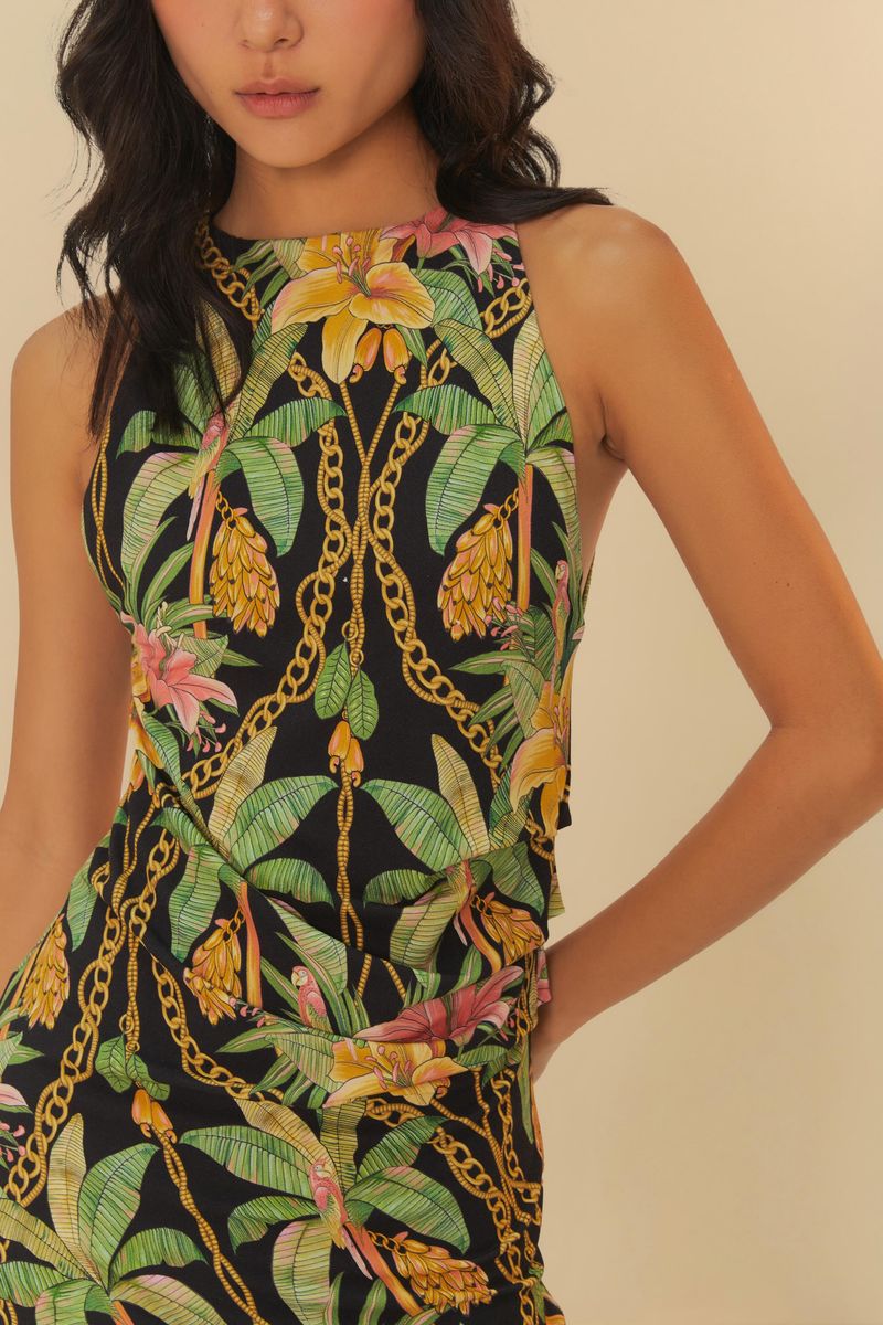 Detalle del estampado tropical del vestido corto, con elementos como hojas y flores.