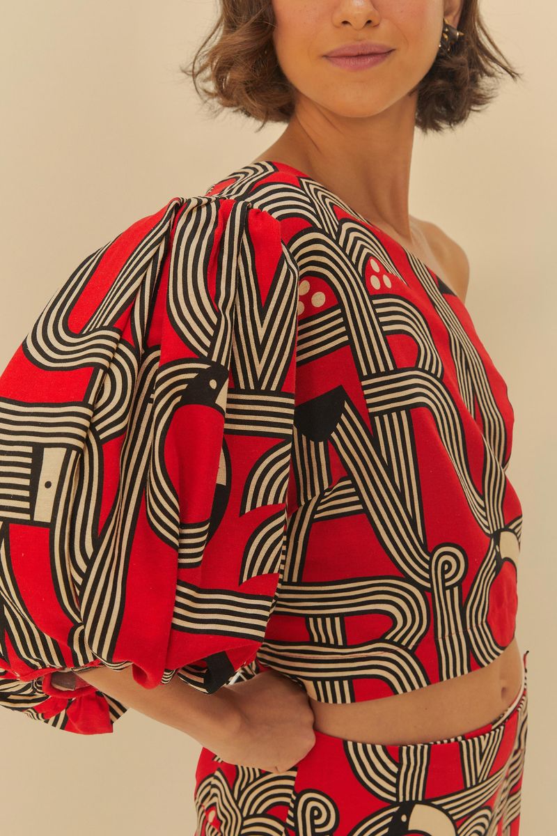 Detalle de la manga abullonada de la Blusa de un Solo Hombro Logotuca con estampado geométrico.